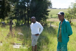 My guide, Sibongiseni (L) and the cemetery worker look on at HH Budd's grave site